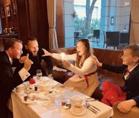 a group of people sitting at a table with a candle